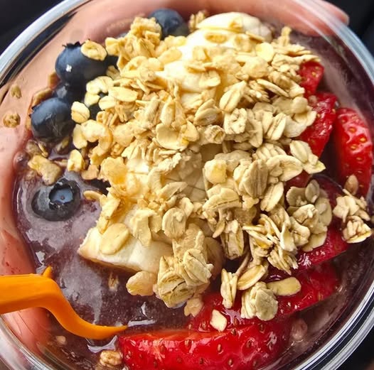 Acai bowl with fruits and oats being held
