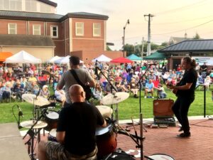 Band Playing drums and guitar crowd watching outside venue