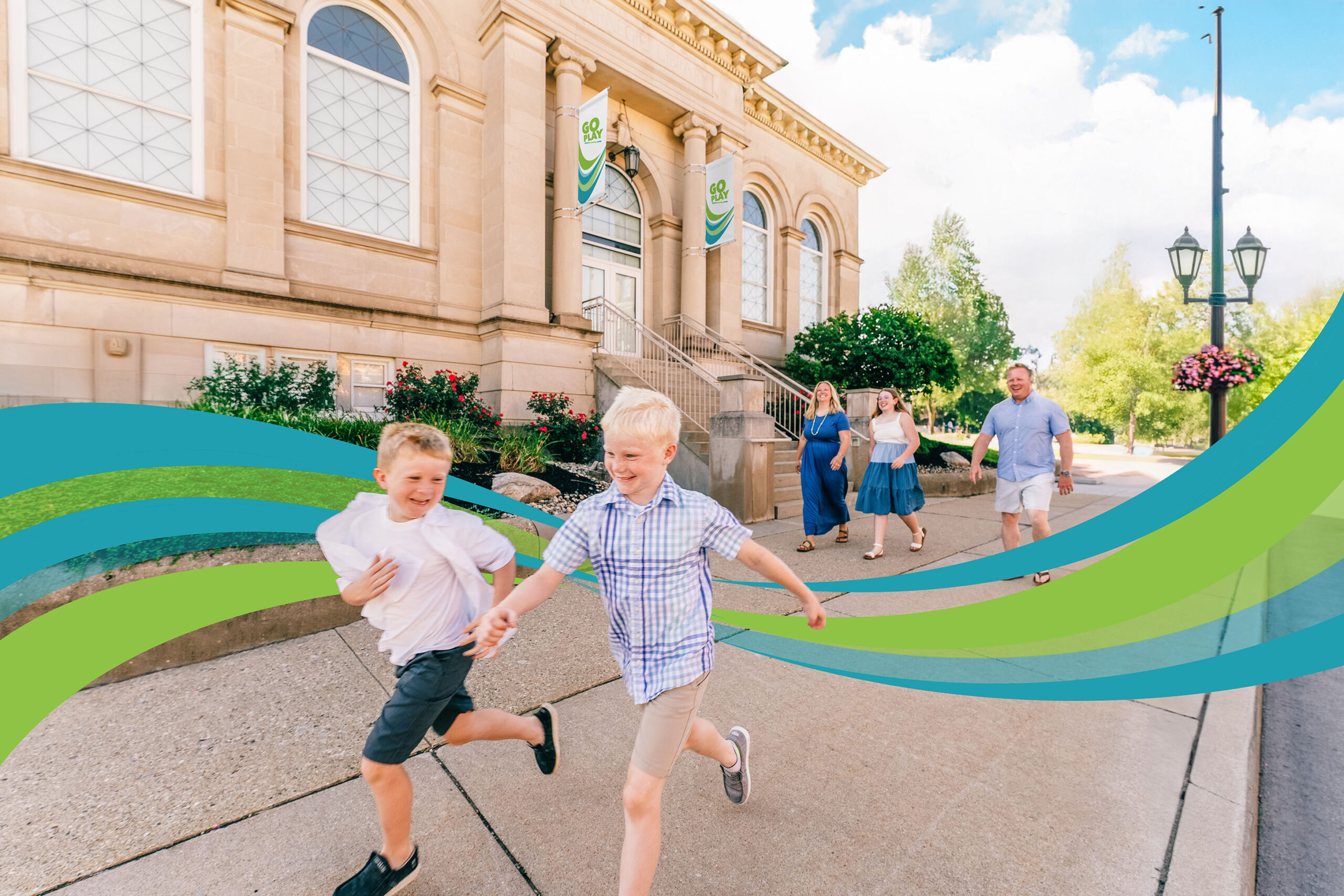 Two young boys running ahead of their parents and sister in front of the Carnegie Museum in Crawfordsville, Indiana
