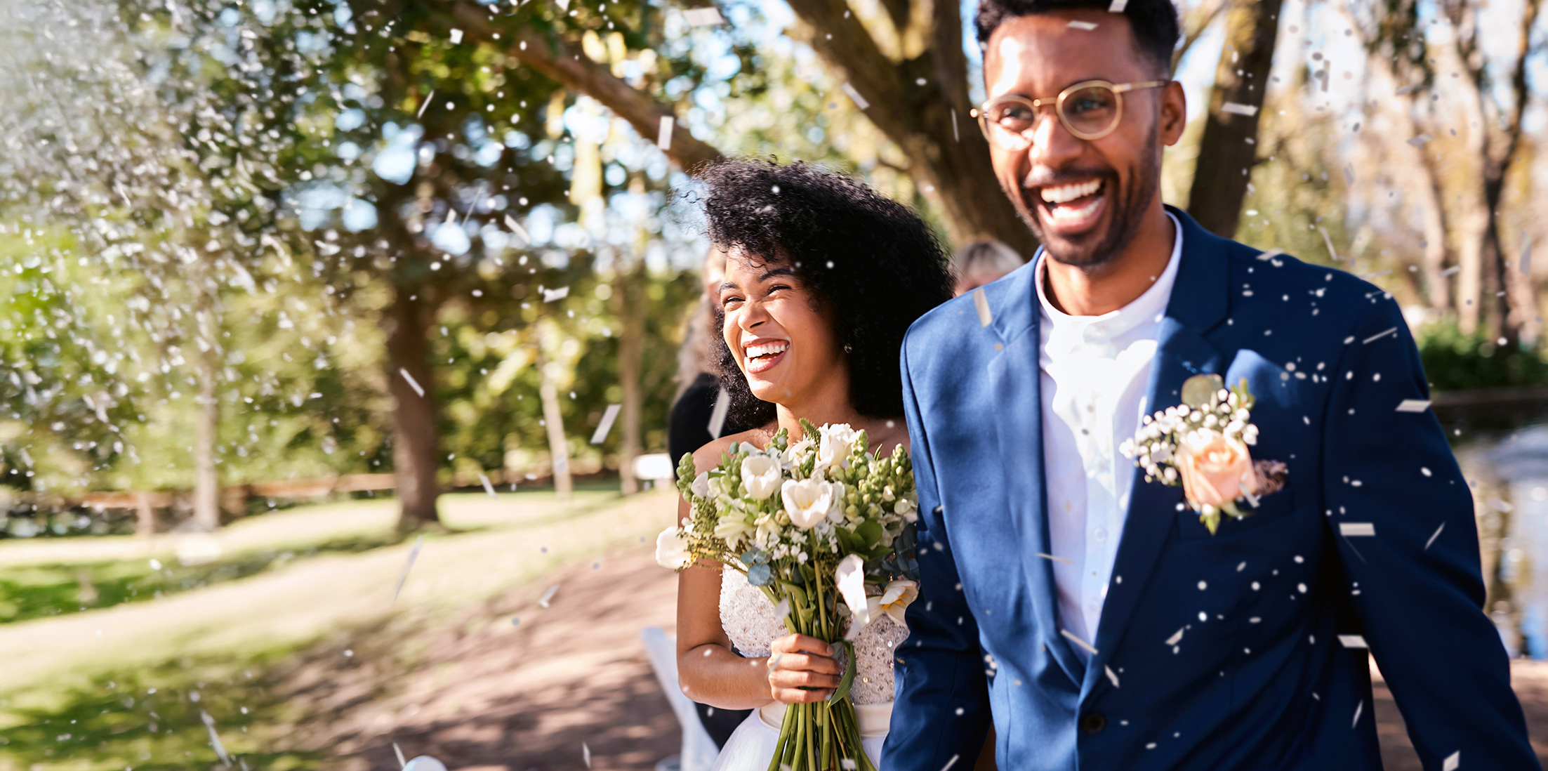 A young couple smiles while walking up the aisle of their wedding